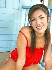 Pajar Buabun sits on a porch and she has on a red dress that hugs her body. Her amazing tits are exposed as she rubs on them.